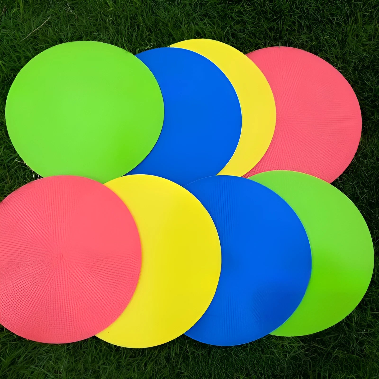 Soft TPE football training marker disc in yellow, 23 cm diameter, lying flat on grass.