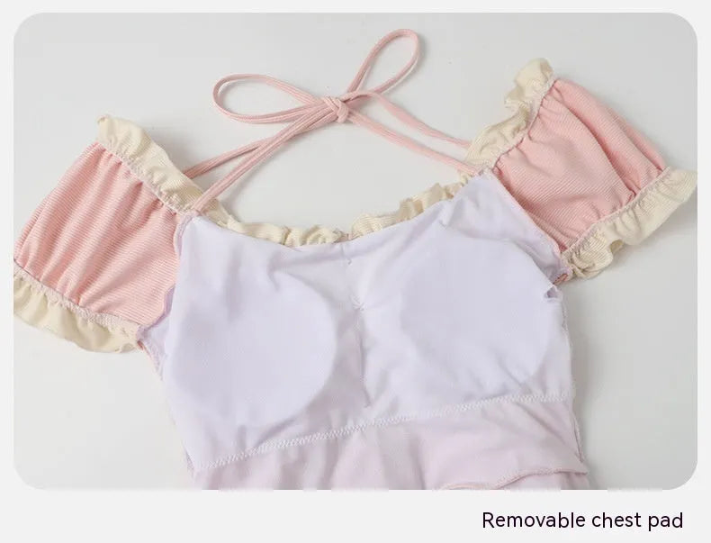 Pink women's one-piece swimsuit with conservative coverage and Siamese design details