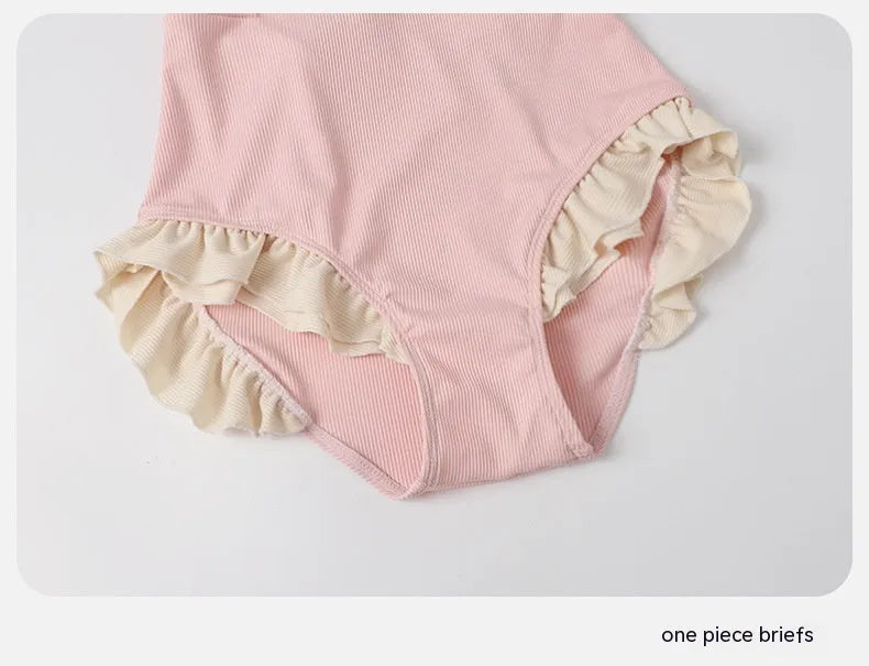 Pink women's one-piece swimsuit with conservative coverage and Siamese design details