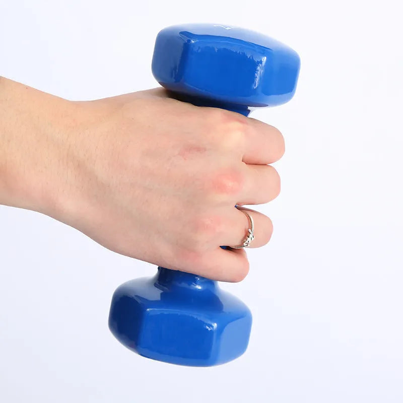 Bright coloured plastic-coated fitness dumbbell showing glossy finish on a home gym floor.