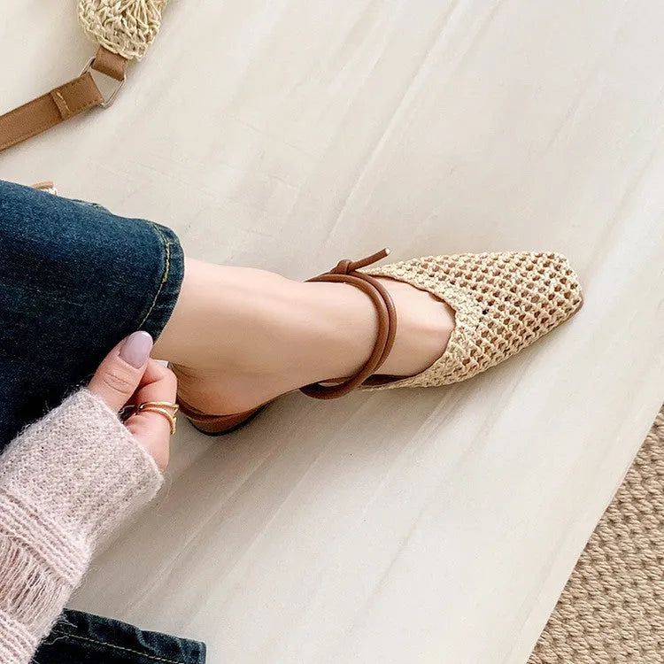 Women's black square toe slippers with chunky heel and breathable hollow-out design on a wooden floor