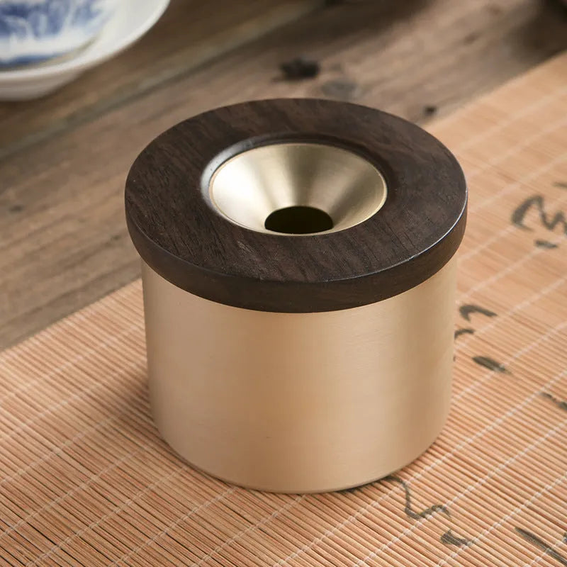 Brass ashtray with wooden lid showing centre hole design and copper construction
