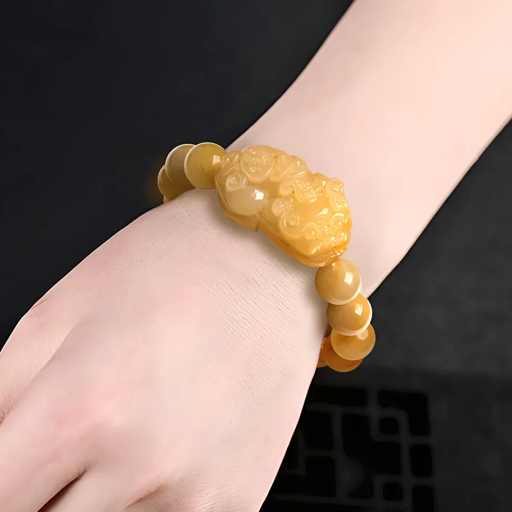 Hand-carved Golden Thread Jinsi Jade money bracelet showing carved detail, offered in large and small unisex sizes.