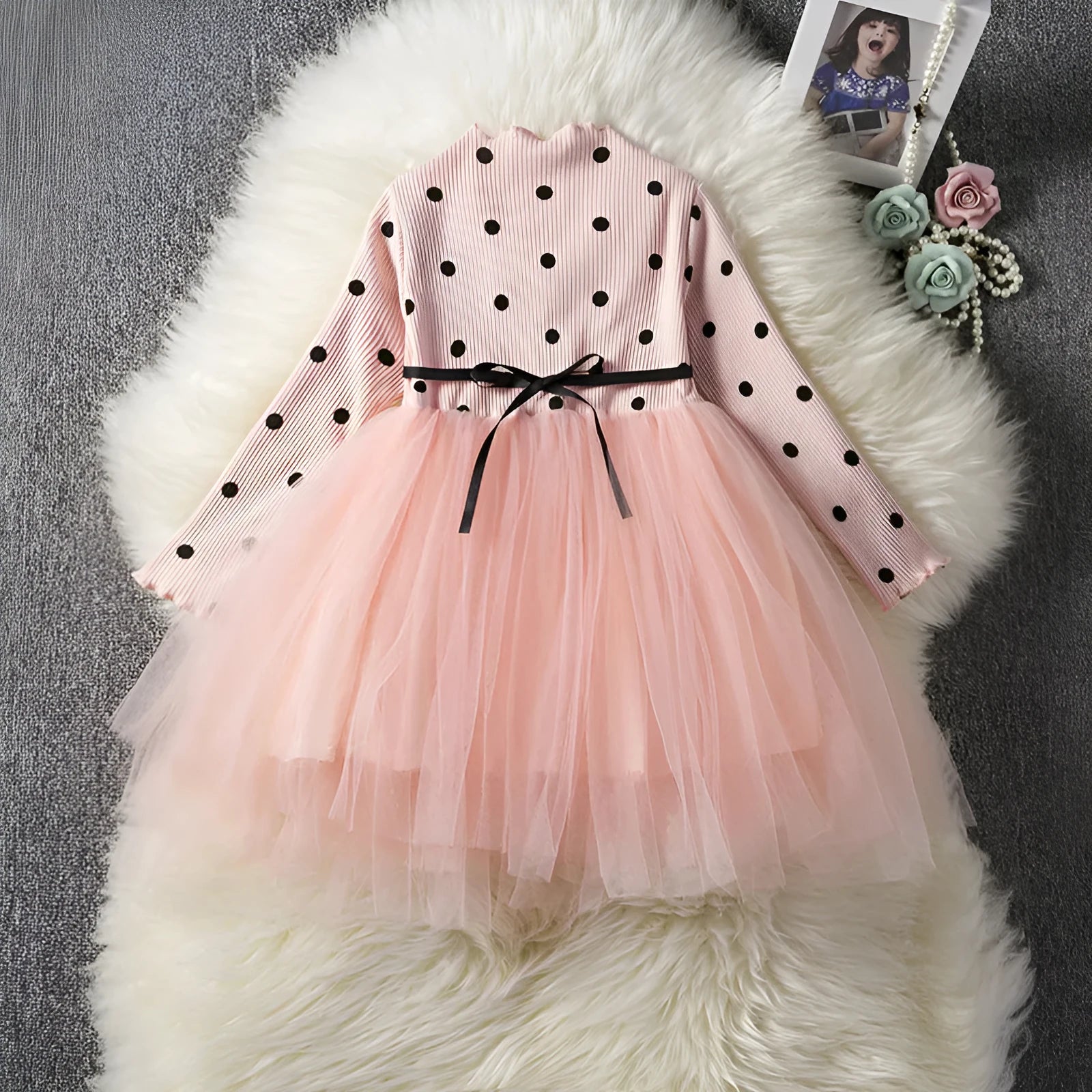 Baby girl wearing a long sleeve black tutu dress with lace detail, suitable for a party or casual wear.