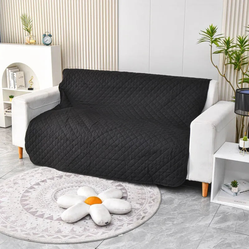 Reversible dog blanket on a sofa showing two colour sides, available in multiple sizes.