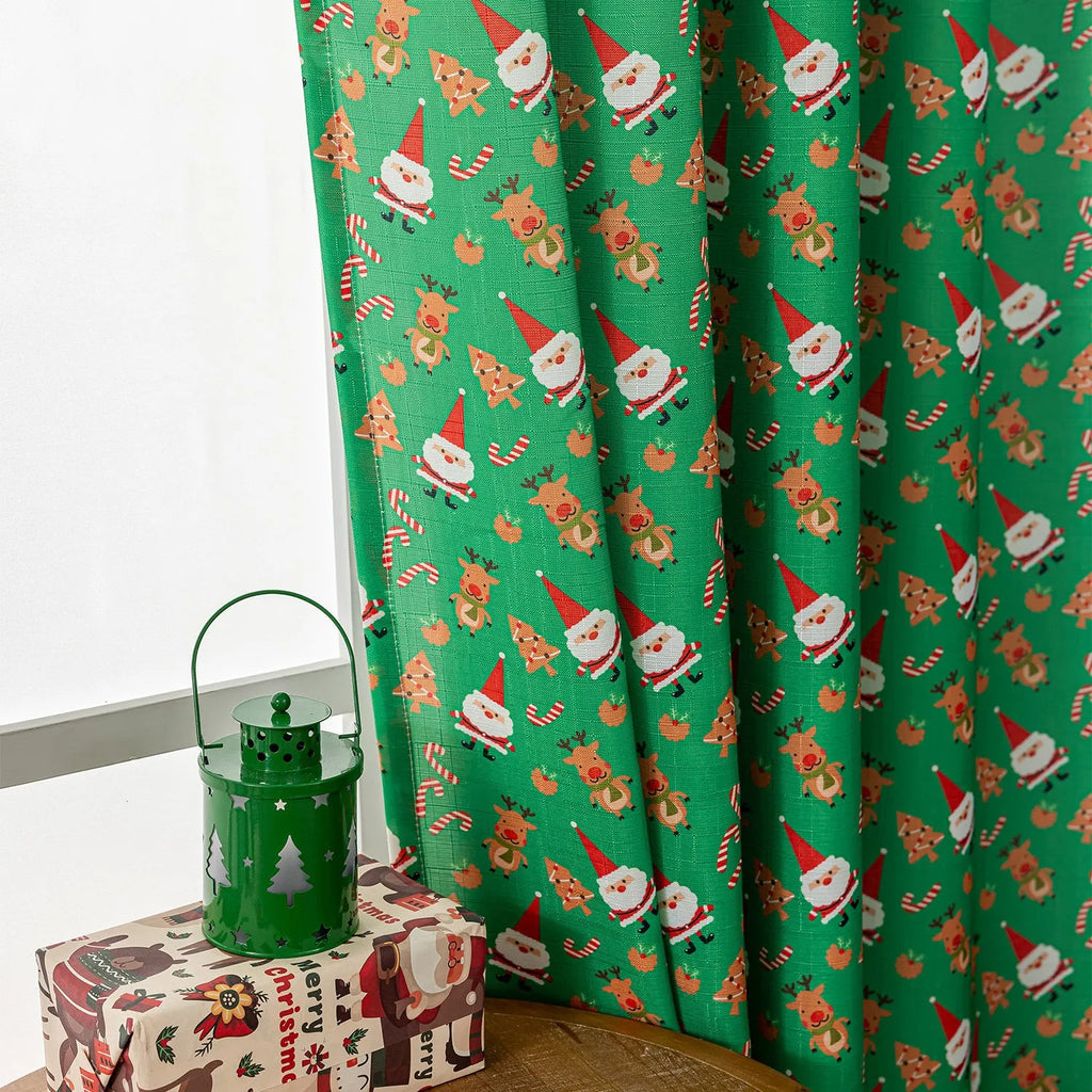 Green festive curtain with printed cartoon snowman and angel pattern.