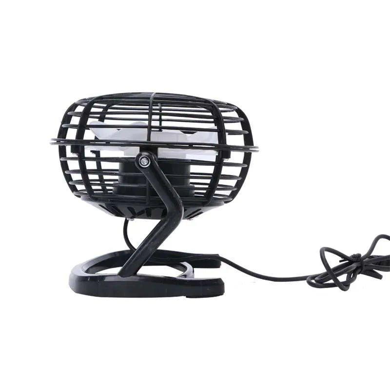 Compact black USB desk fan with adjustable tilt angle on a wooden desk next to a laptop
