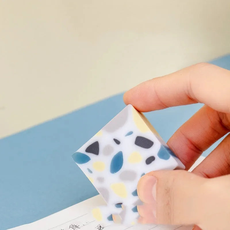 A single brick-shaped white rubber eraser for removing pencil marks.