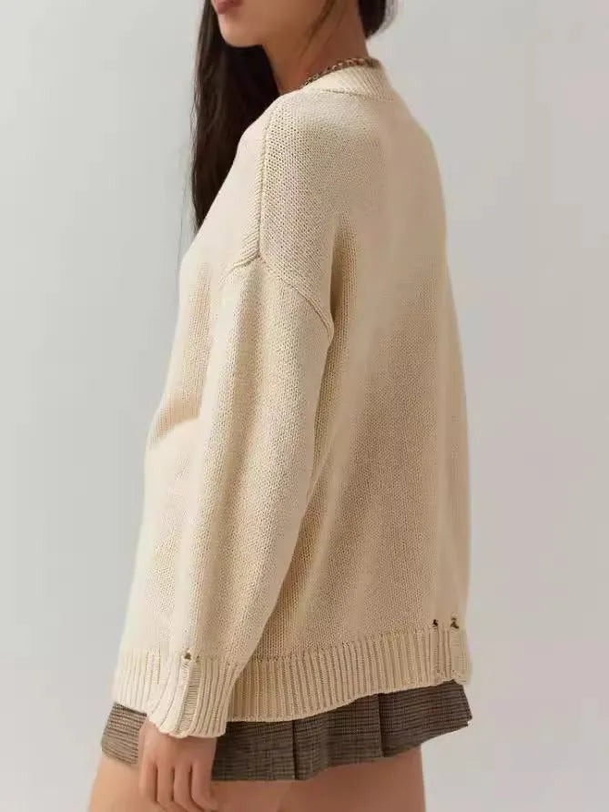 Women's milky white acrylic Jacquard pullover sweater with round neck and long sleeves on a hanger.