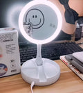 White acrylic double-sided vanity mirror with LED lights and a foldable stand.