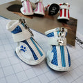 Set of four blue cloth dog sneakers with zip fasteners and non-slip soles laid out.