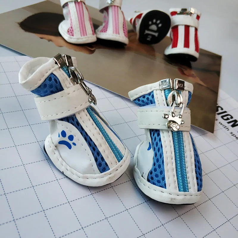 Set of four blue cloth dog sneakers with zip fasteners and non-slip soles laid out.