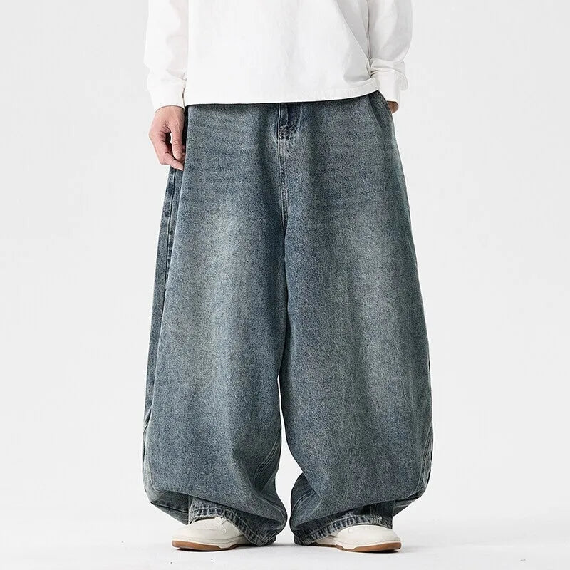 Men's plus size baggy blue jeans with wide straight legs on a hanger.
