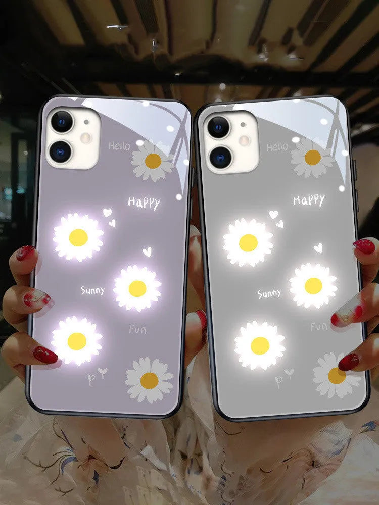 White and purple luminous iPhone cases with painted daisies and voice-activated colour lights on a table.