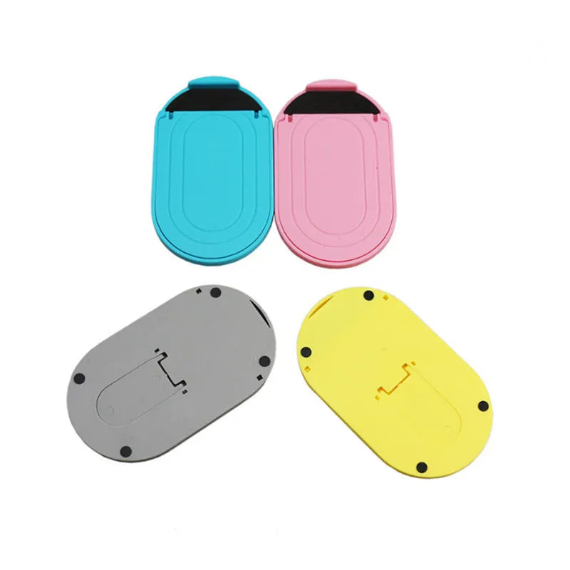 A plastic lazy bracket phone stand holding a mobile smartphone on a table.