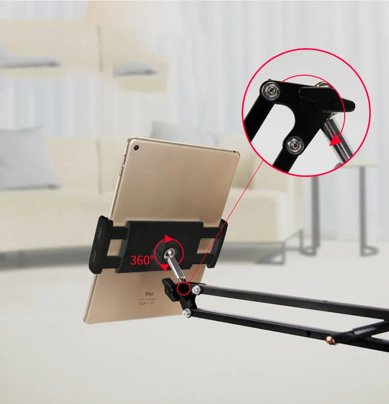Black adjustable phone tablet stand with 360-degree rotation on wooden table