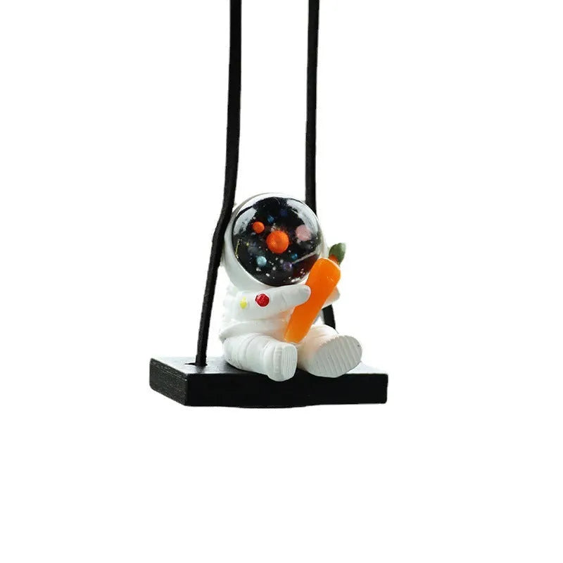 Resin cartoon astronaut car pendant charm in red flag design hanging from a rearview mirror.