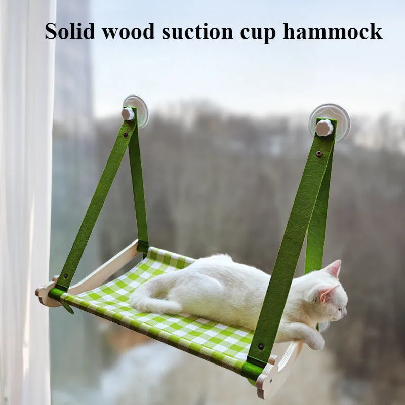 Foldable wooden cat window hammock with suction cups attached to a glass pane.