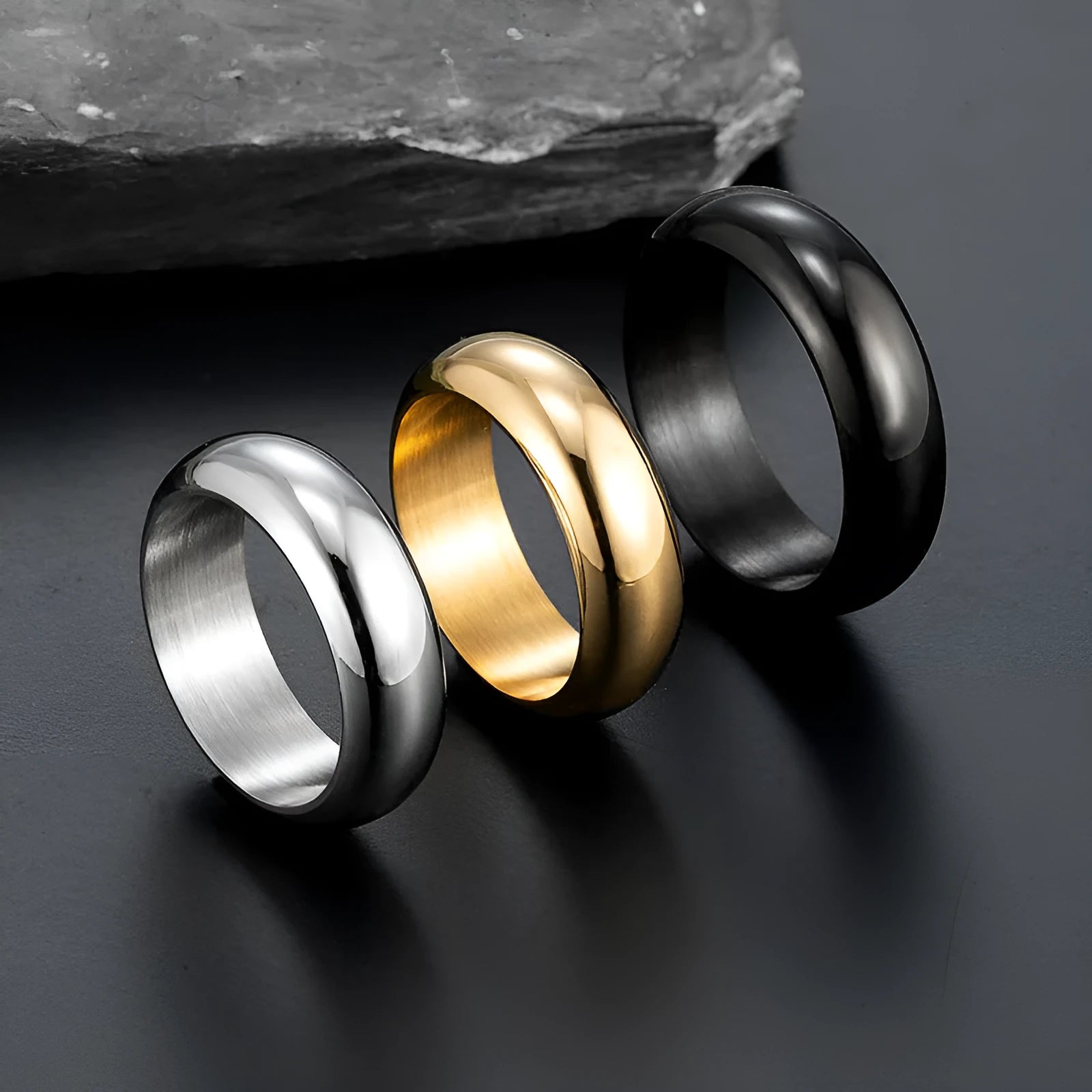 Glossy electroplated titanium steel ring shown in gold, black, and steel colour on a grey background.