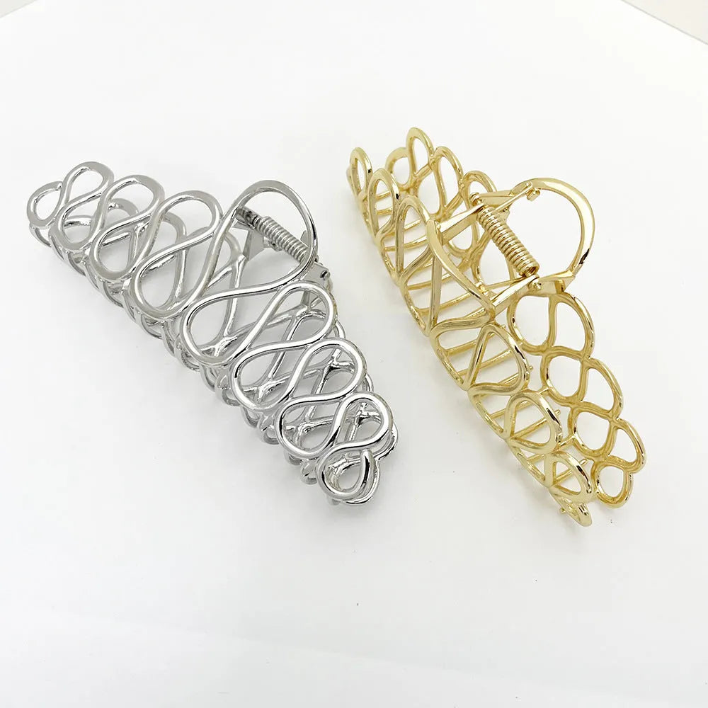 Large minimalist hair clip with tassel decoration in gold finish showing irregular shape design