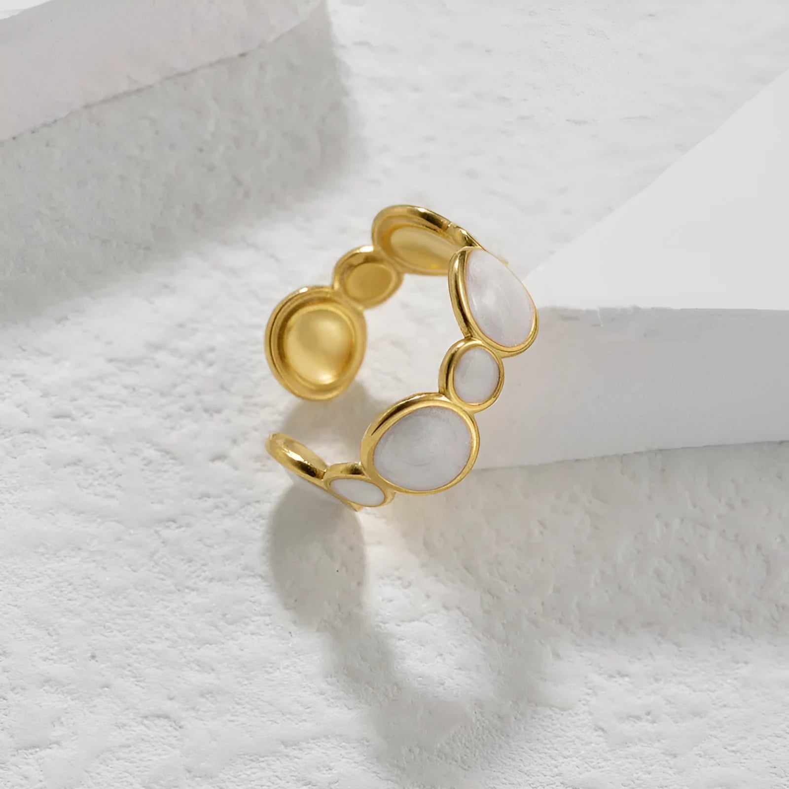 Silver-tone geometric stainless steel ring with an adjustable opening on a plain background.