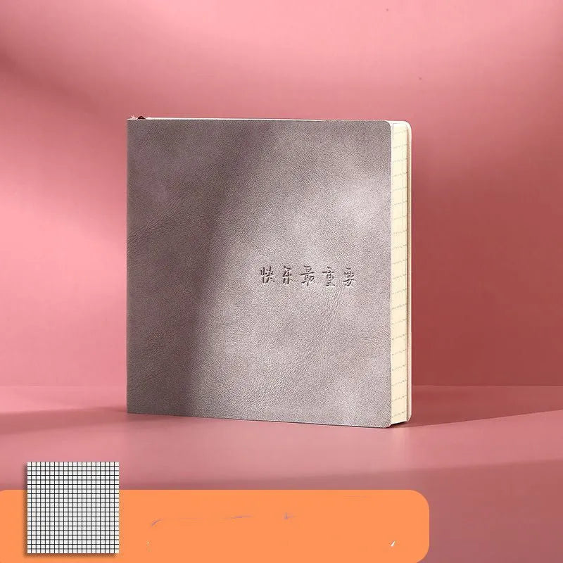 Square faux leather notebook with French fold binding, open on a blank Daolin paper page.