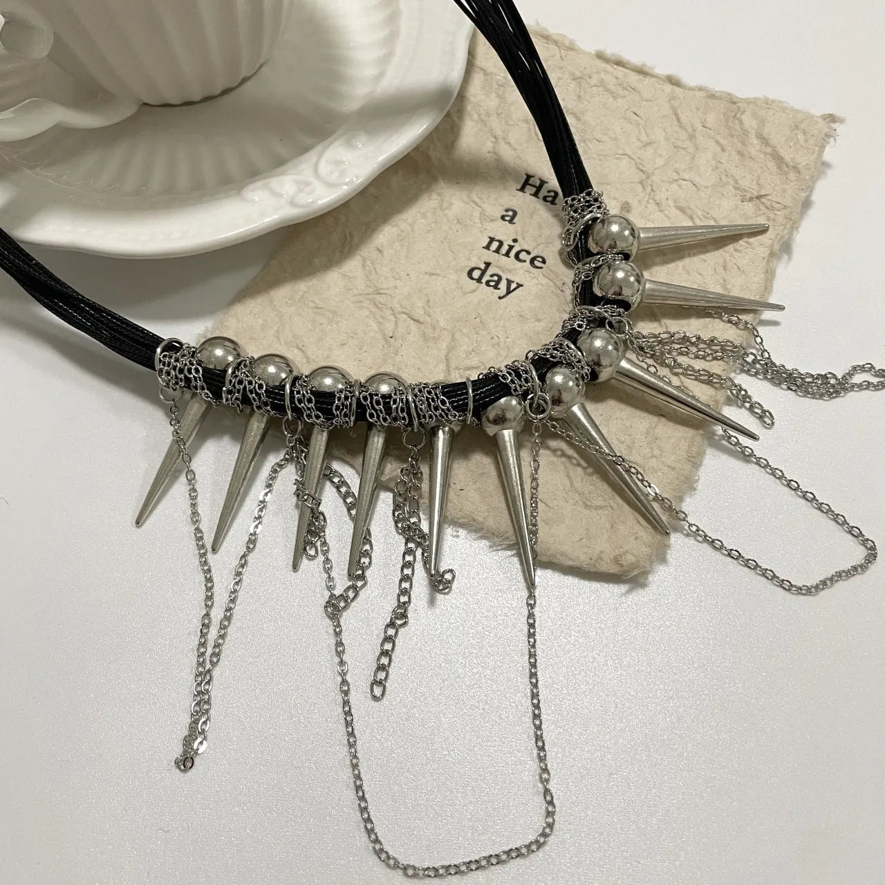 Women's leather tassel necklace with winding beads and silver rivet details in picture colour.