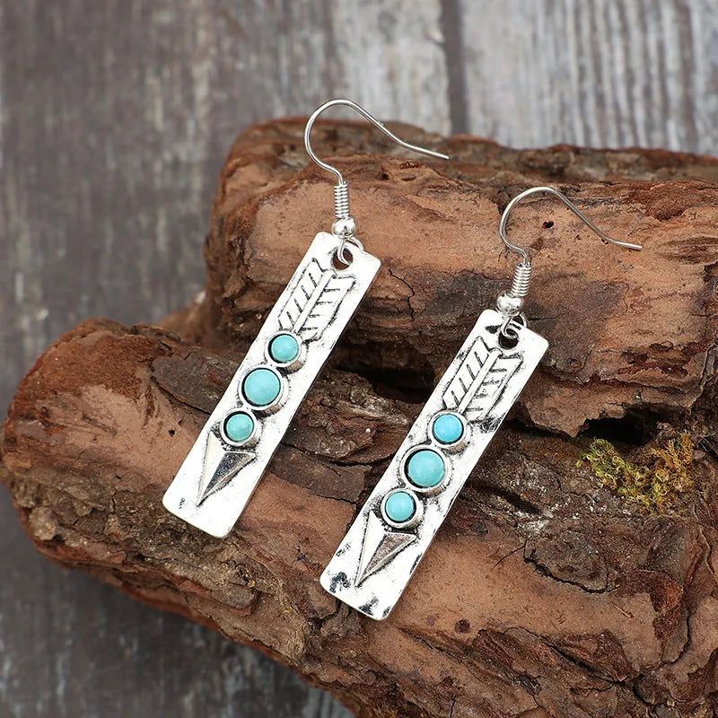 Silver geometric drop earrings with turquoise coloured inlays showing retro styling