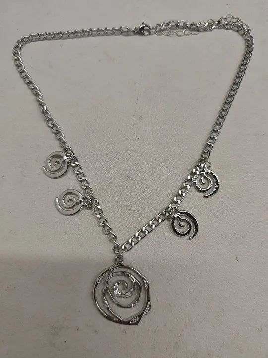 Gold tone spiral donut design necklace, bracelet, and earrings set on a white background.
