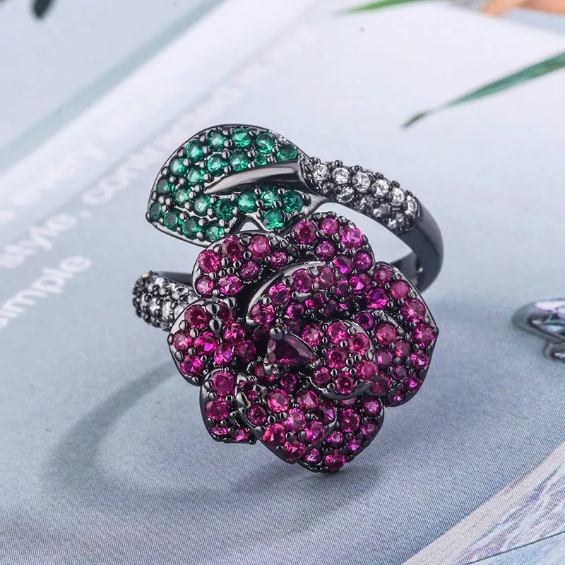 Gold-plated geometric flower ring with red simulated corundum stone on black gold finish