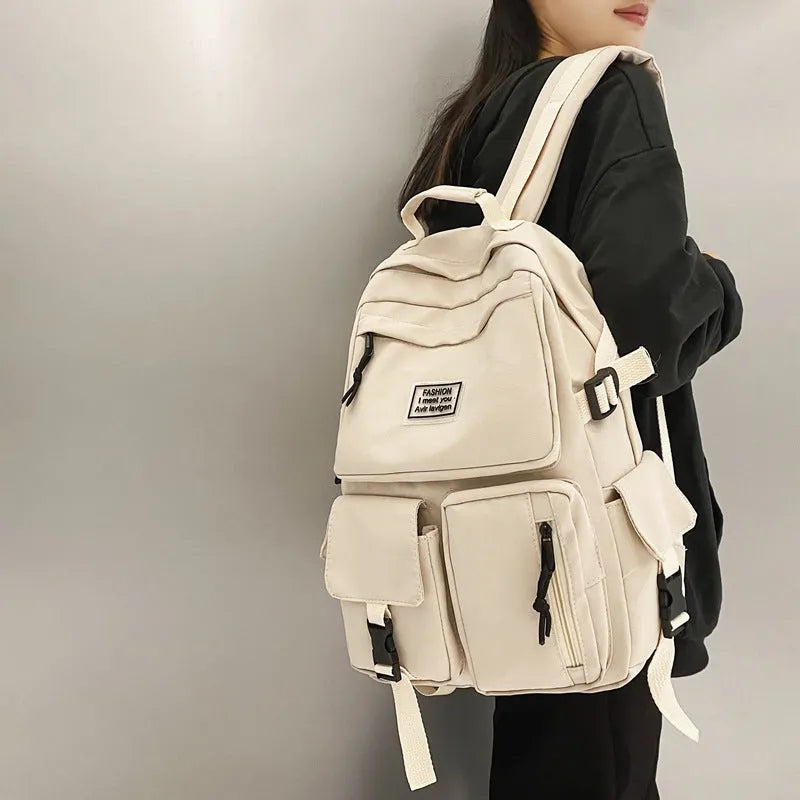 Black and white nylon student backpack with laptop compartment and three-dimensional outer pockets.