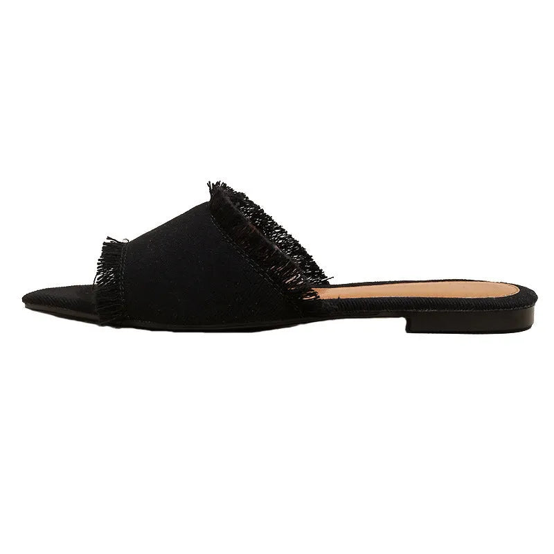 Women's denim flat slippers with tassel detail in apricot colour on a white background.