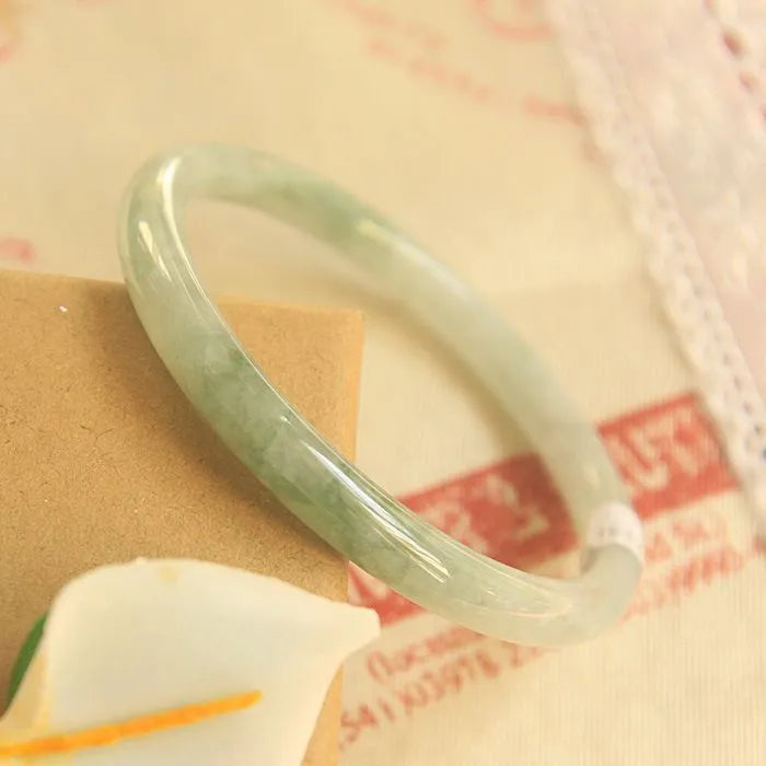 Green geometric Chinese style jade waxy bracelet shown on a wrist, highlighting its 10mm width and detailed pattern.