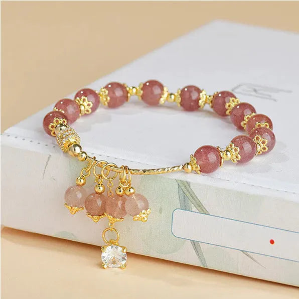 Pink women's bracelet with heart-shaped strawberry quartz crystals and pearl bead accents on adjustable band