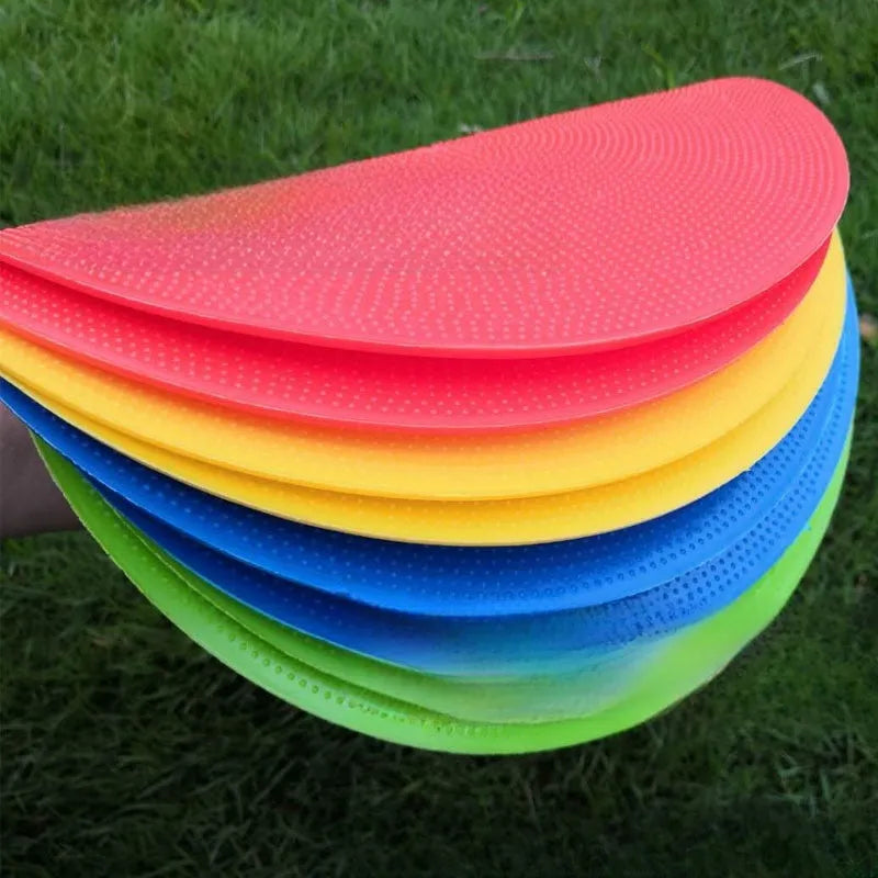 Soft TPE football training marker disc in yellow, 23 cm diameter, lying flat on grass.