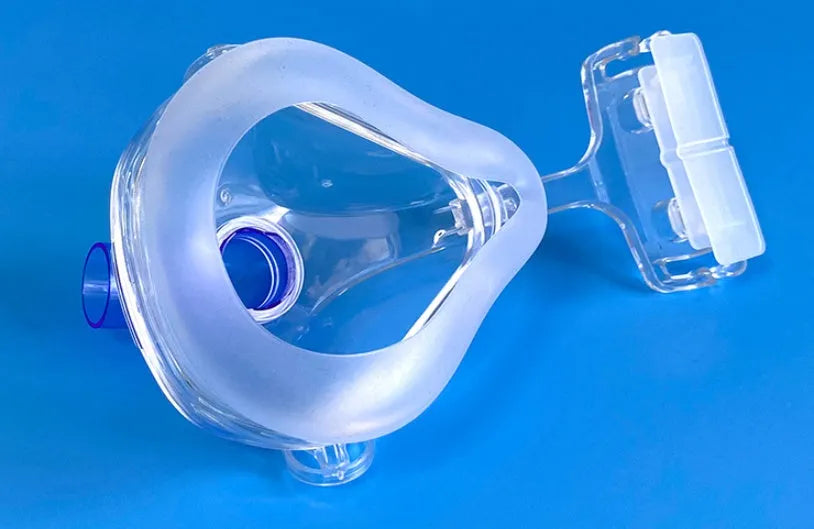 Transparent silicone CPAP breathing mask with headband and two PC adapter elbows on a white background.