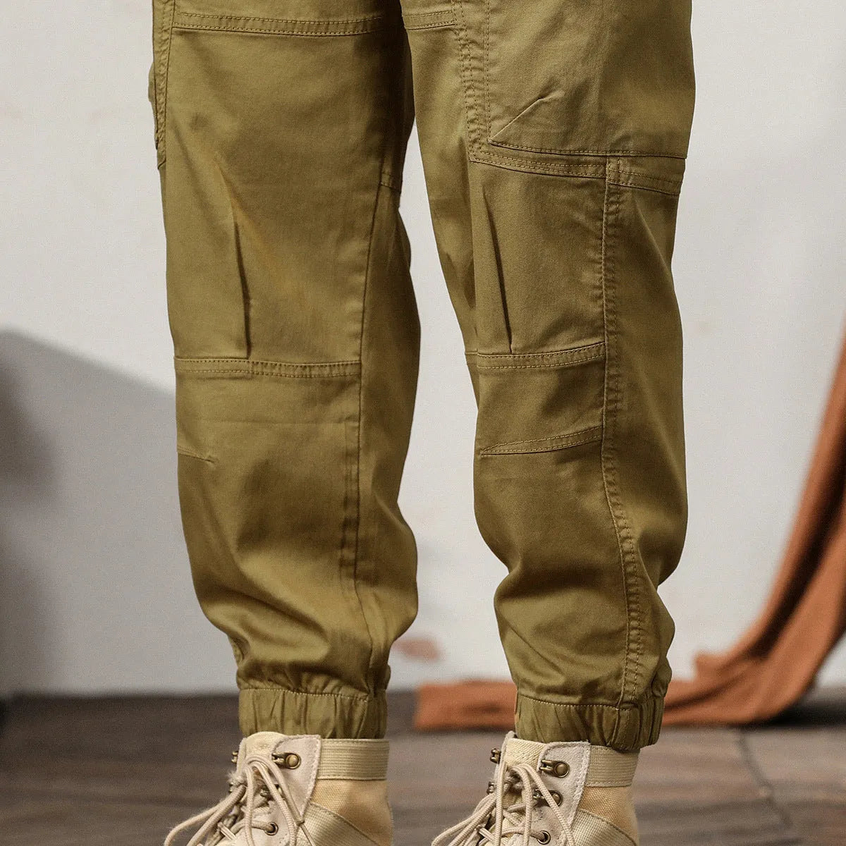 Men's loose cotton harem pants in khaki with a tapered ankle opening and zip fly.