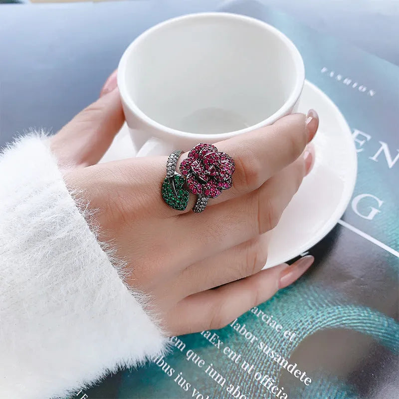 Gold-plated geometric flower ring with red simulated corundum stone on black gold finish