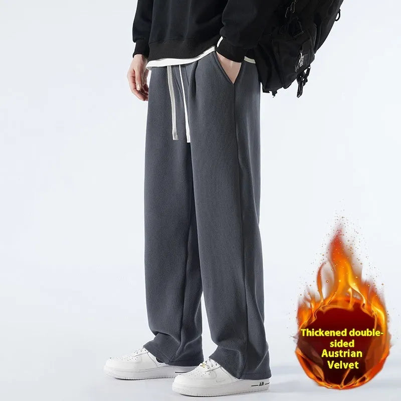 Men's apricot fleece-lined loose-fit sports casual trousers with elastic waist on a hanger.