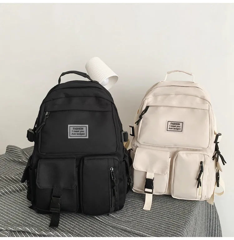 Black and white nylon student backpack with laptop compartment and three-dimensional outer pockets.