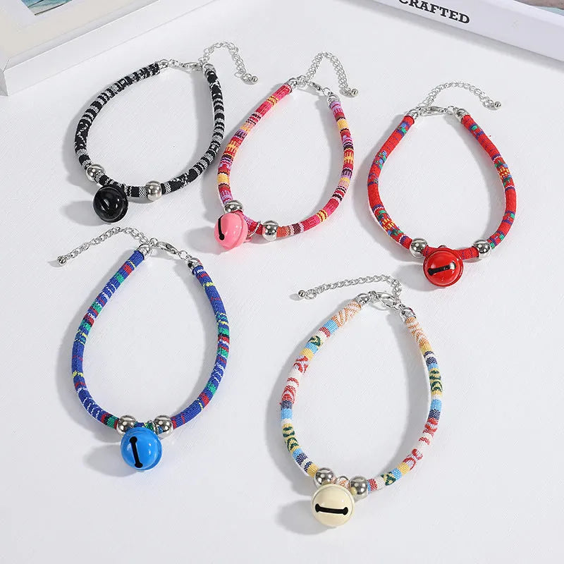 Adjustable ethnic pattern pet collar with a bell, shown in various colours for cats and small dogs.
