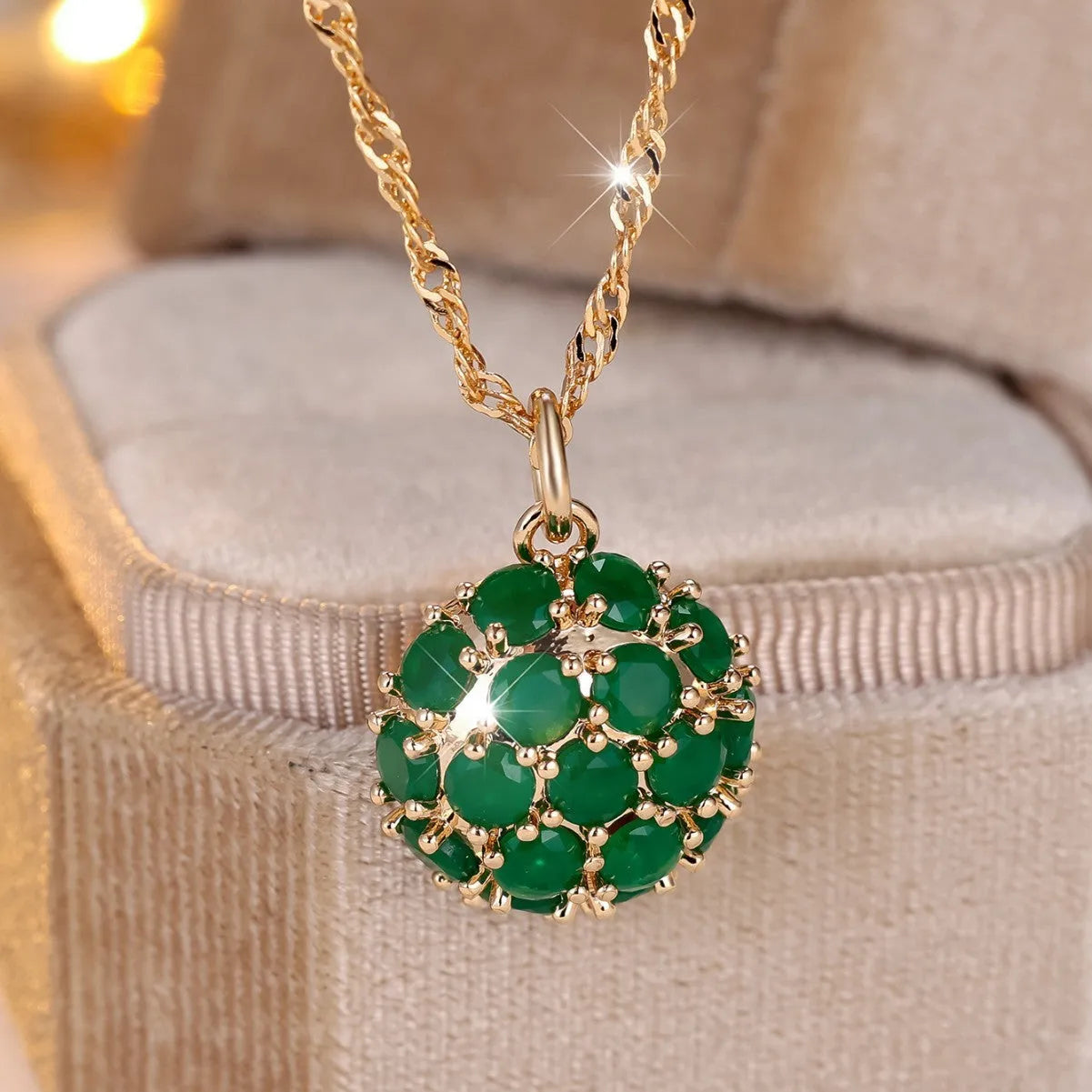 Round emerald and diamond pendant on an adjustable champagne gold electroplated copper chain necklace.