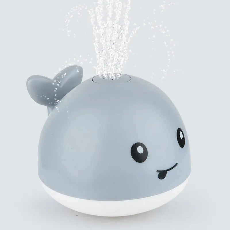 Automatic electric whale bath toy spraying water with flashing coloured lights