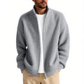 Man wearing a loose grey cardigan sweater with button-up front and V-neck.