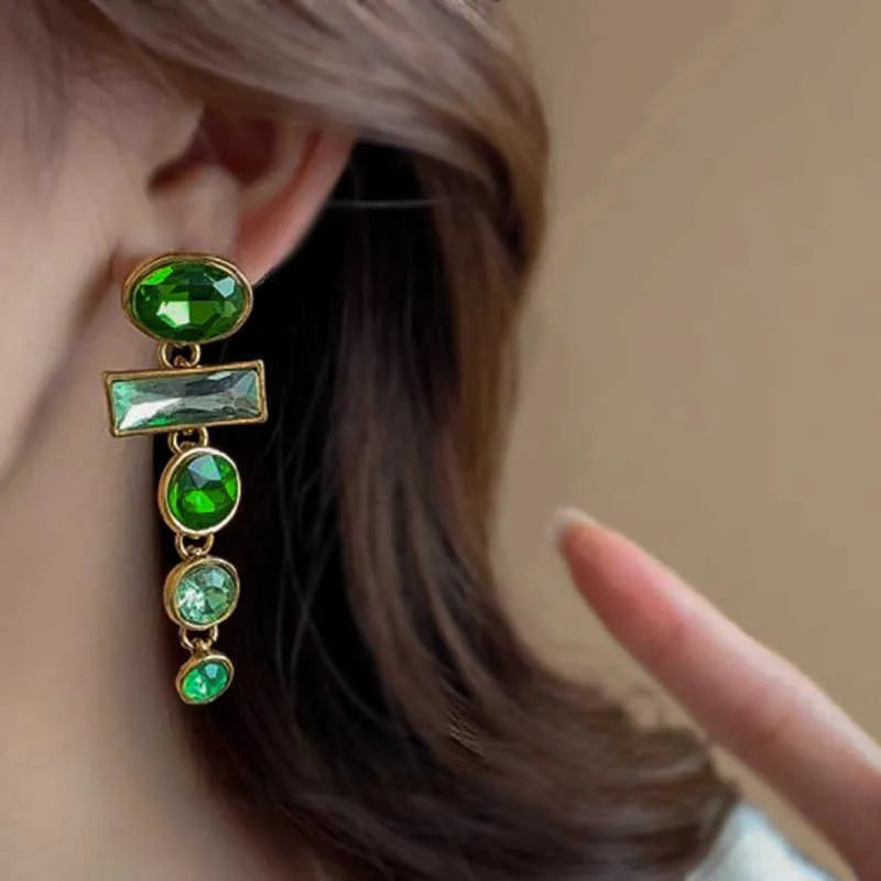 Close-up of green gradient geometric alloy earrings with long tassels and sparkling inlaid zircons.
