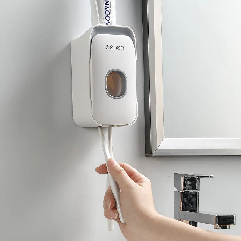Blue automatic toothpaste dispenser with wall-mount bracket on a bathroom wall