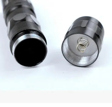 Compact black aluminium LED mini flashlight showing scale against a hand