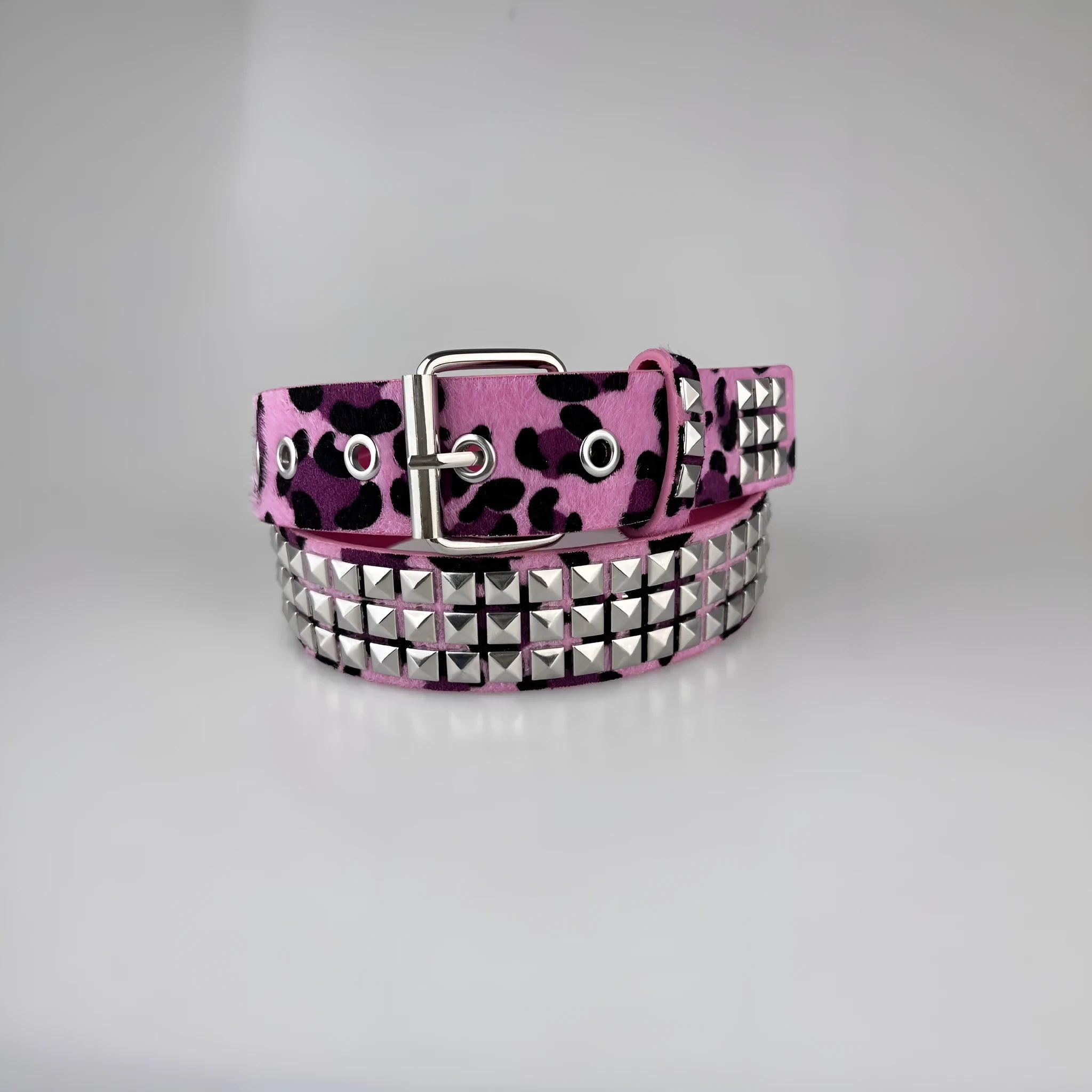 Women's punk fashion belt with metal rivets and pyramid studs in leopard print pattern, showing adjustable buckle