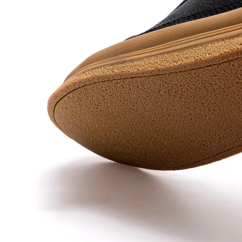 Men's black leather casual shoes with round toe, flat heel, and white laces on a rubber sole.