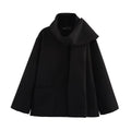 Women's long black polyester overcoat with a gray artificial fur collar, showing street fashion style and front pockets.